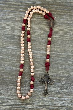 a rosary with a cross hanging from it's end on top of a wooden table