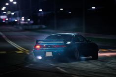 a car driving down the road at night