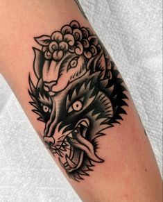 a black and white photo of a tattoo on someone's arm with a wolf head