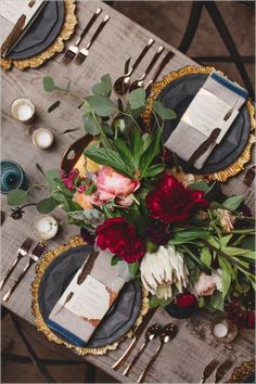 the table is set with flowers and place settings for dinner guests to sit down at