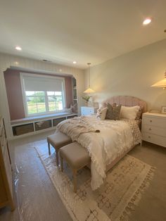 a bedroom with a bed, dresser and window