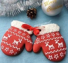 two decorated cookies sitting on top of a table next to a christmas ornament