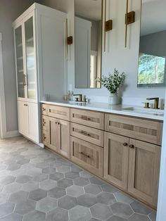 a large bathroom with two sinks and mirrors on the wall, along with tile flooring