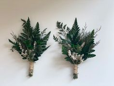 two green and white flowers are placed next to each other on the wall in front of a white background