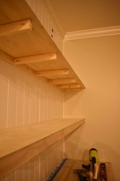 the shelves are made out of plywood and have been built into the wall for storage