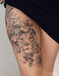 a woman's thigh with a lion and roses tattoo on it