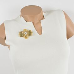 This lovely Gianfranco Ferre couture pin brooch features a dimensional gilt metal geometric shape, all paved with crystal clear rhinestones and topped with two massive champagne resin cabochons. A security closing clasp at the back with the Ferre, Made in Italy hallmark underside. Measurements: 2.50 in wide (6.3 cm) x 2.07 in high (5.2 cm).  Please see the measurements noted above in the description for the best approximate dimensions. Elegant Metal Brooches For Parties, Elegant Yellow Gold Brooches For Party, Elegant Yellow Gold Party Brooches, Chic Gold Brooch For Evening, Formal Gold Jeweled Brooches, Gold Jeweled Brooches For Formal Occasions, Luxury Yellow Gold Brooches For Parties, Elegant Gold Metal Brooches, Gold Wedding Brooches Chic Style