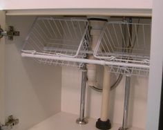 a kitchen sink with two baskets on the bottom and one shelf above it that is open