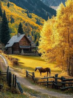 a horse that is standing in the grass near a fence and some trees with yellow leaves