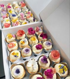 there are many cupcakes in the box and one is decorated with flowers on it