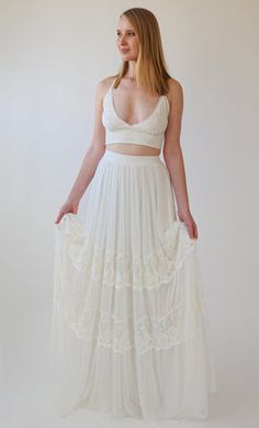 a woman is wearing a white dress and has her hands on her hips