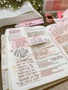 an open bible with writing on it and flowers in the backgroung area