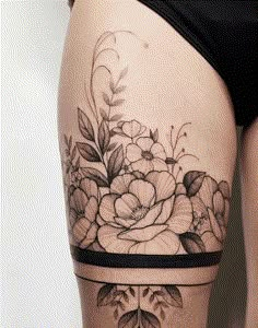 a woman's thigh with flowers and leaves tattoo on her side ribcage