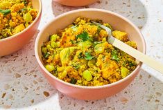 two bowls filled with rice and vegetables on top of a table next to each other