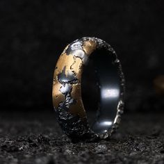 Opvallende robuuste ring van geoxideerd 925 zilver en messing voor een mooie betaalbare goud look.  De ring wordt helemaal met de hand gemaakt. Dit wil zeggen dat er een mal gemaakt wordt die gebruikt wordt om een zandafdruk van te maken. Deze zandafdruk is gemaakt in oliegebonden zand en naderhand wordt het gesmolten zilver er in gegoten. Nadat deze afgekoeld is wordt dit juweel afgewerkt zodat er geen scherpe kantjes meer aan zitten en zodat deze mooi glimt. Dit gebeurt doormiddel van het juweel te vijlen, schuren en polijsten. Door deze techniek is iedere ring uniek. Deze ring heeft een dikte van ongeveer 3mm en een breedte van ongeveer 8mm. Maar is in ieder gewenste breedte of model te krijgen in deze structuur.  Ook als set ring voor dames en heren.  Op bestelling gemaakt. Ook verkrij Unique Bronze Rings For Anniversary, Round Patina Rings For Anniversary, Bronze Hammered Ring As Gift, Bronze Hammered Rings As Gift, Hammered Bronze Rings As Gifts, Hand Forged Metal Rings, Bronze Patina Ring, Unique Gold Rings With Patina, Hand Forged Metal Rings For Anniversary