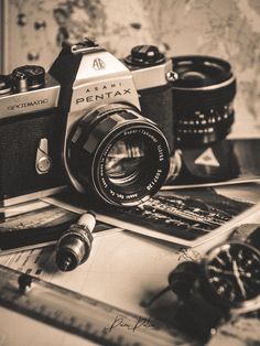 an old camera sitting on top of a table next to other items and papers with writing