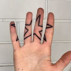 a person's hand with two small black arrows on it, and the middle finger