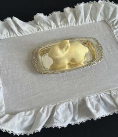 a small tray with some yellow icing on it and a white ruffled edge