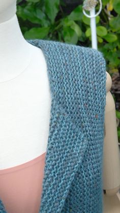 a blue knitted vest sitting on top of a mannequin's torso