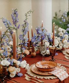 the table is set with flowers and candles