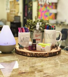 an assortment of office supplies sitting on top of a wooden table next to a lamp