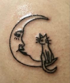 a cat sitting on top of a crescent moon tattoo