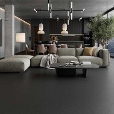 a modern living room with black walls and flooring, large sectional couches in the center