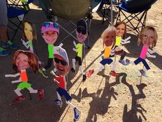 a group of paper cut out of people wearing hats and sunglasses, standing in the sand