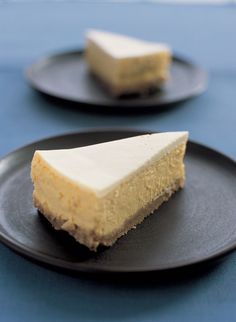 two black plates with slices of cheesecake on them