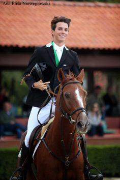 a man riding on the back of a brown horse