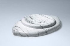 two marble coasters sitting on top of each other in front of a white background