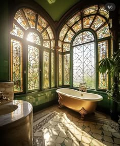 an ornate bathroom with stained glass windows and a claw foot bathtub in the center