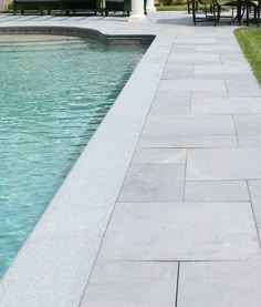 an outdoor patio and swimming pool with chairs