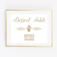 a white and gold dessert table sign with a cupcake in the middle on it