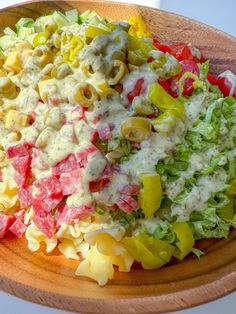 a wooden bowl filled with pasta salad and dressing