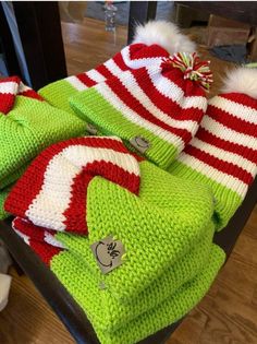 several knitted christmas hats and scarves are on display in a store window sill