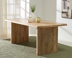 a wooden table sitting on top of a carpeted floor next to a vase and potted plant