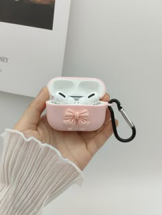 a person holding an airpods case with a cat face on it's side