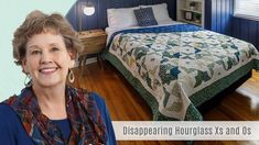 a woman standing next to a bed in a room with blue walls and wooden floors