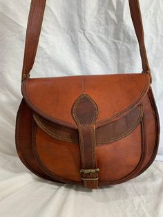 "Measurements are 13\" wide, 10\"5 high, 3\"4 deep with a 54\" shoulder strap at it's longest with a 24\"5 drop. On the interior there is one main compartment with 2 back zipper pocket, two back pockets, lined in twill fabric and a front pocket under flap closure. Leather is lightly oil waxed with brass tone hardware and one exterior pocket for easy access. The leather is strong with no tears and bag can be used crossbody. This bag is great for work,school and daily use. ------------------------ Leather Flap Bag With Brass Hardware For Everyday Use, Vintage Shoulder Bag For Fall, Vintage Bags With Leather Lining For Fall, Vintage Leather Shoulder Bag For Fall, Vintage Soft Leather Shoulder Bag For Fall, Leather Saddle Bag For Daily Use In Fall, Fall Leather Lined Satchel Shoulder Bag, Fall Leather Saddle Bag For Daily Use, Brown Flap Shoulder Bag With Brass Hardware