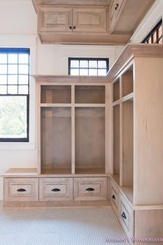 an empty walk - in closet with drawers and cabinets next to a wall mounted window