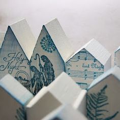 several small wooden houses sitting next to each other on top of a white tablecloth