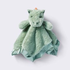 a green teddy bear wrapped in a satine blanket on a white background with an orange tag attached to it