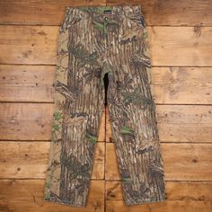 a pair of camouflage pants on a wooden floor