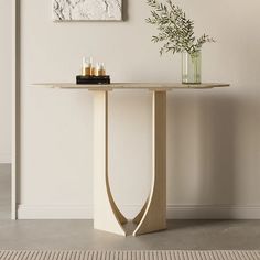 a table with candles on it in front of a painting and vase filled with flowers