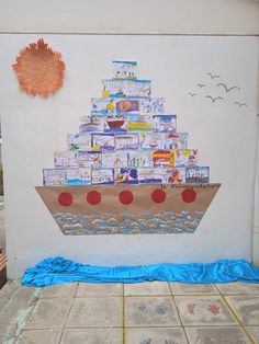 a paper boat made out of children's books sitting on the side of a building