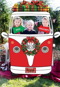 a vw bus decorated for christmas with two children in the window and presents on top