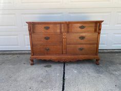 an old wooden dresser sitting in front of a garage door