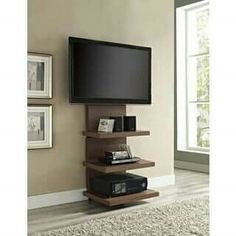 a flat screen tv sitting on top of a wooden shelf