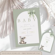 a baby announcement card with a koala bear on the front and green ribbon around it